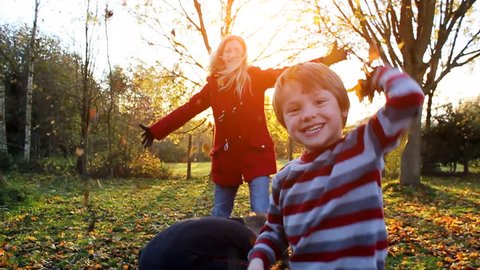 Happy family playing outdoors with autumn leaves. High quality HD video footage