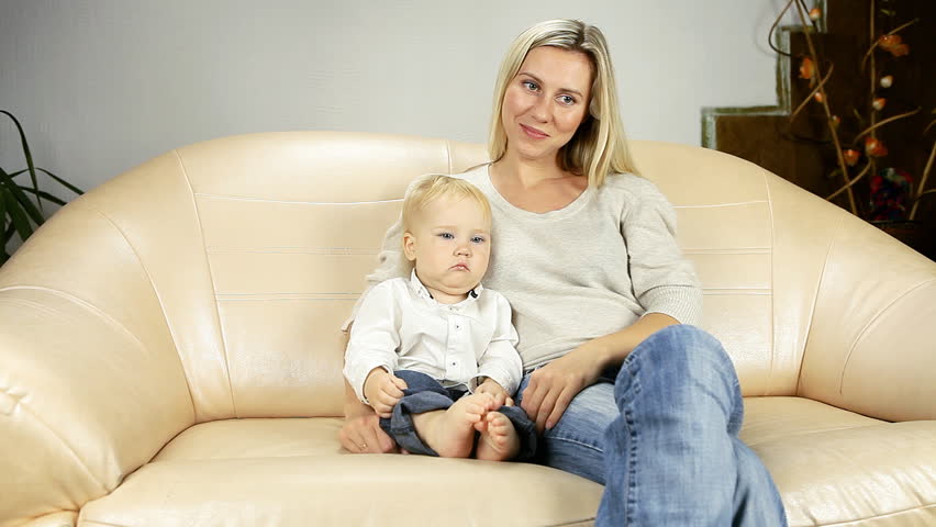 Mother with son on sofa watch TV 