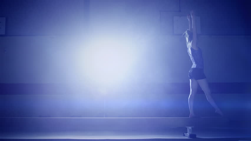 Female gymnast performing on a balance beam in slow motion. Olympics sport in contemporary setting. Slow motion Shot on RED Epic at 240FPS Royalty-Free Stock Footage #4495694