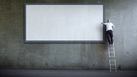 Man erects billboard poster for advertising. Blank wall for copy space advertising. Part of a series of artistic clips I'm calling 'Wall Street'.