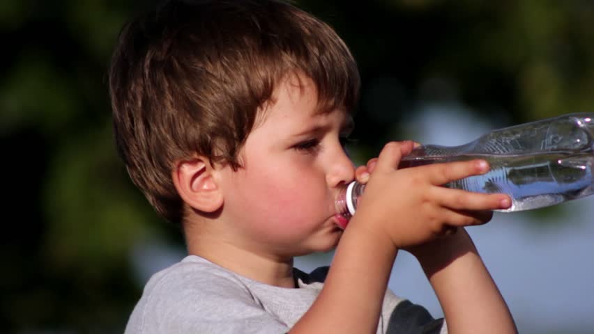 Boy drinkin mineral water from plastic bottle 