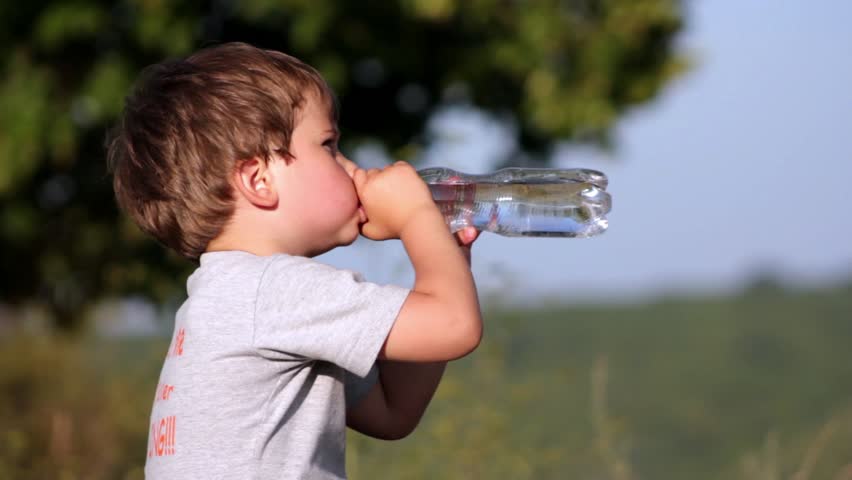 Boy drinkin mineral water from plastic bottle 