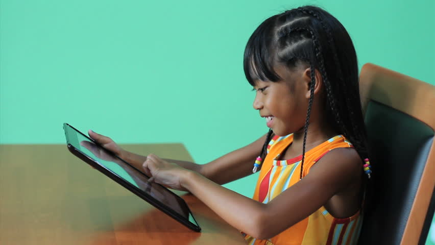 A cute seven year old Asian girl is excited to use her new digital tablet.
