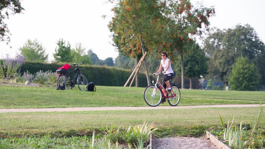 woman rides a bicycle around the city park