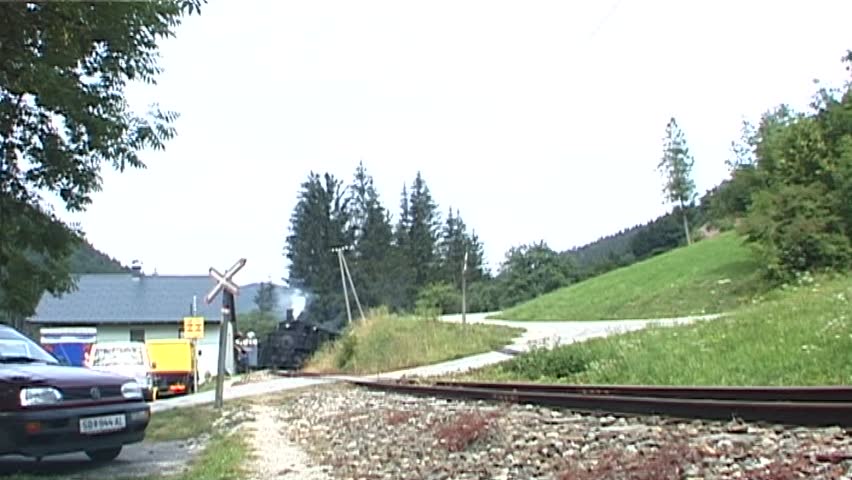 Steam train with historic steam locomotive passing in scenic landscape