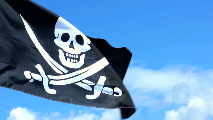 Jolly Roger pirate flag waving over a blue sky.