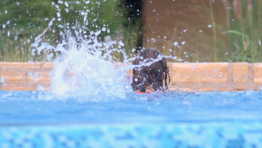 Slow Motion Shot Of A Little Girl Splashing Water With Her Legs In Swimming