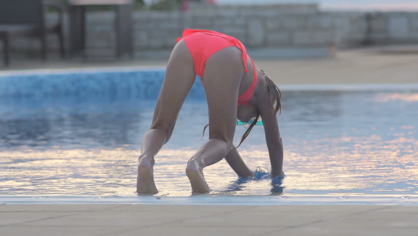 Slow Motion Shot Of A Little Girl Diving Into Swimming Pool Head First