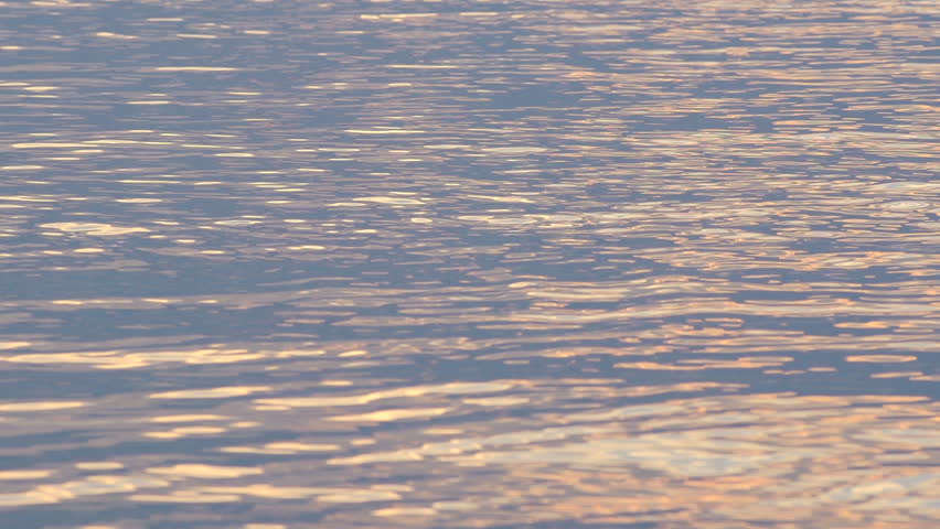 Slow Motion Shot Of Serene Ocean Water Reflecting Late Afternoon Light