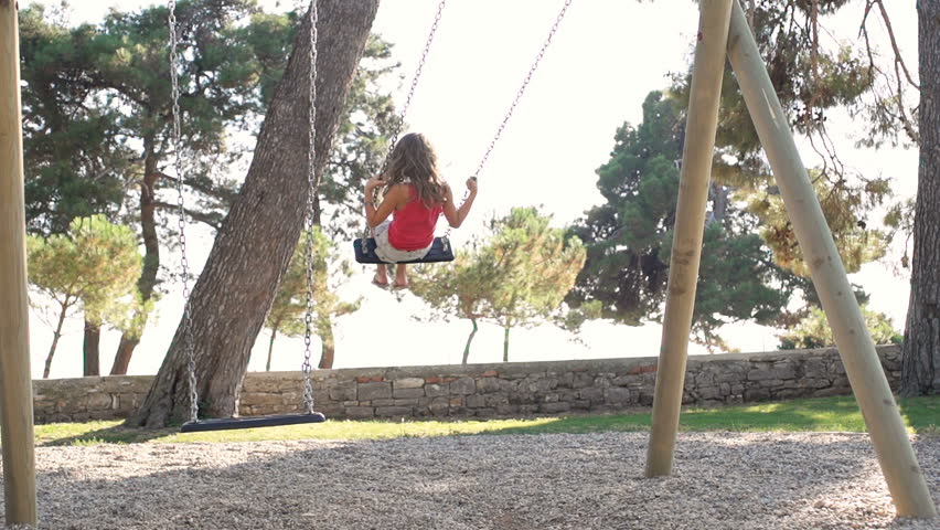 Slow Motion Shot Of A Girl With Long Hair Jumping Off A Swing In Park. Shot In