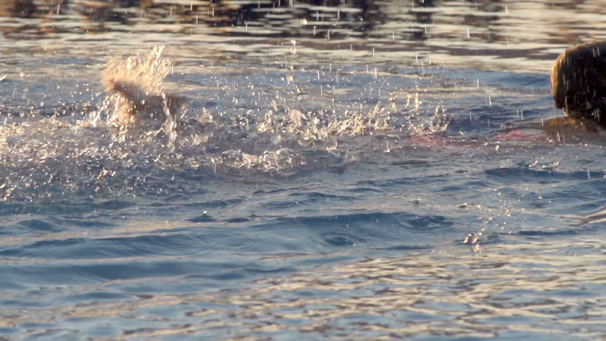 Slow Motion Shot Of A Child Swimming In Ocean And Splashing Water WIth Legs