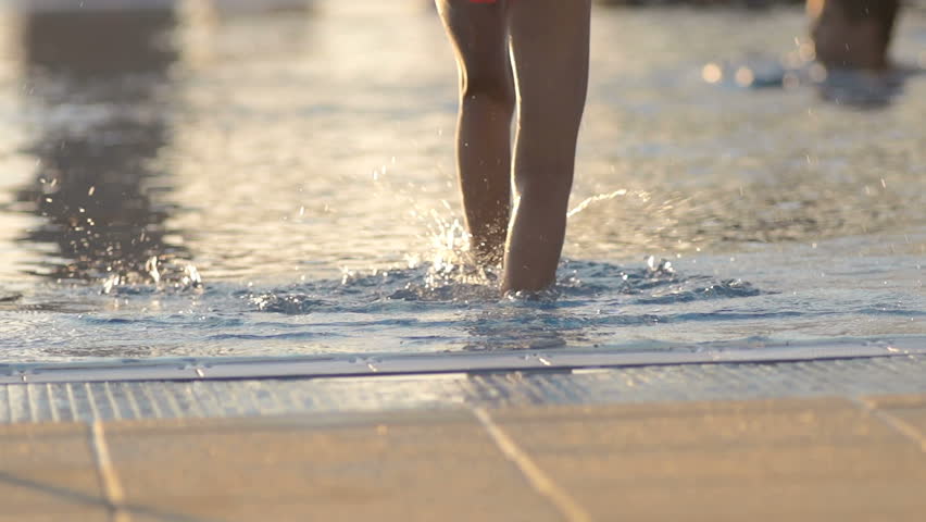 Slow Motion Shot Of A Little Girl Descending Into Swimming Pool. Shot In Her