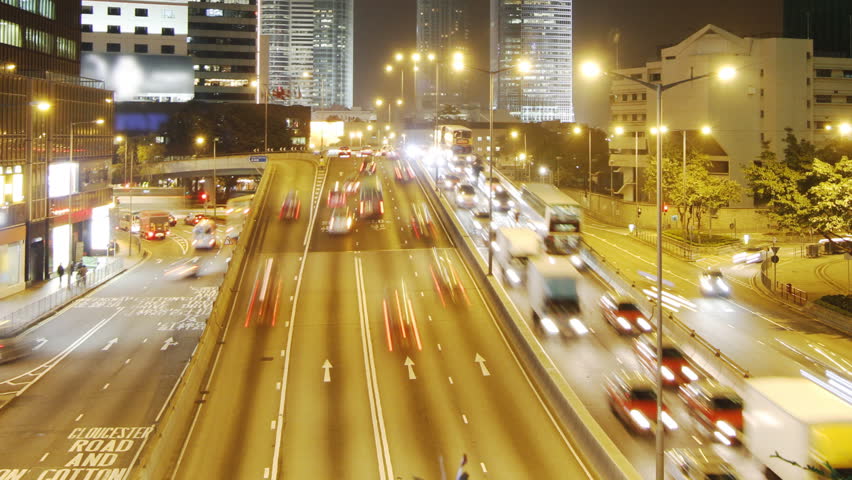 Hong Kong skyscrapers and city traffic at night - tilt up