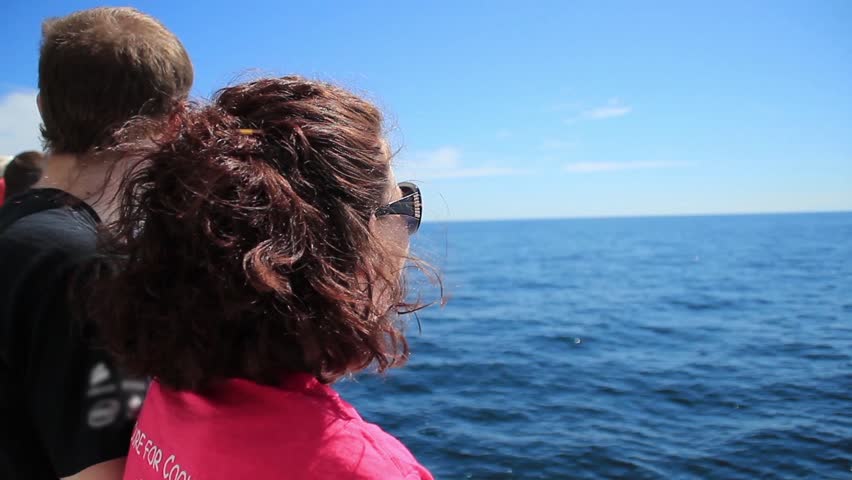 A young couple looks out over the open ocean.