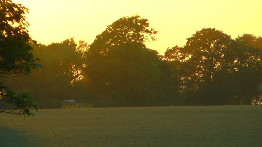 Scenic shot of a combine harvester at sunset