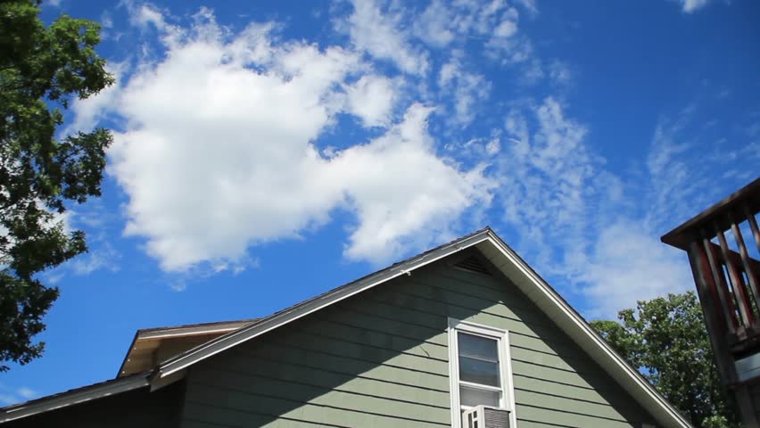 Time lapse summer clouds over a home.
