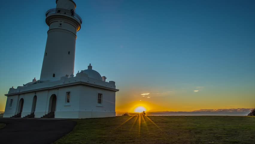 Lighthouse sunrise timelapse with low to high pan.