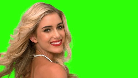 Attractive woman tossing her hair on green screen in slow motion