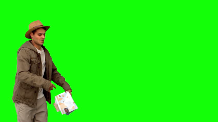 Man with a map and a compass orienteering on green screen in slow motion