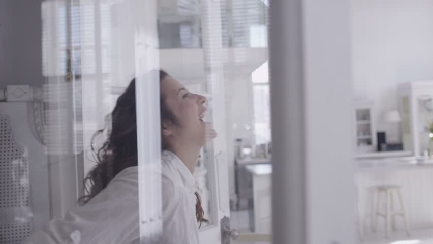 Happy and attractive young mixed race couple viewing a beautiful modern property with a view to making it their home. In slow motion.