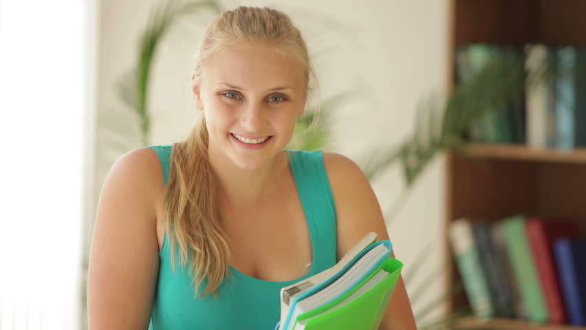 Beautiful young girl holding notebook and smiling