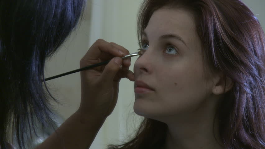 Young actress being made up before a filming session.