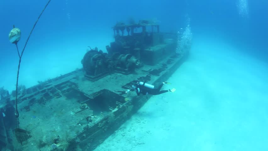 A shipwreck lies on white sand just off the island of Grand Cayman.  The