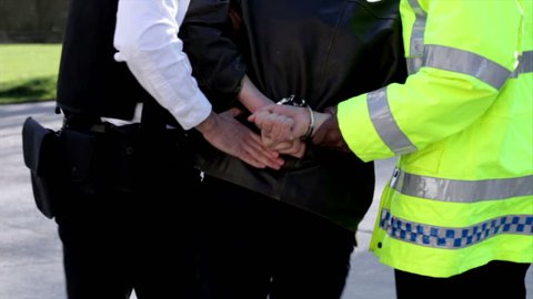 Young person arrested by Police officers and handcuffed