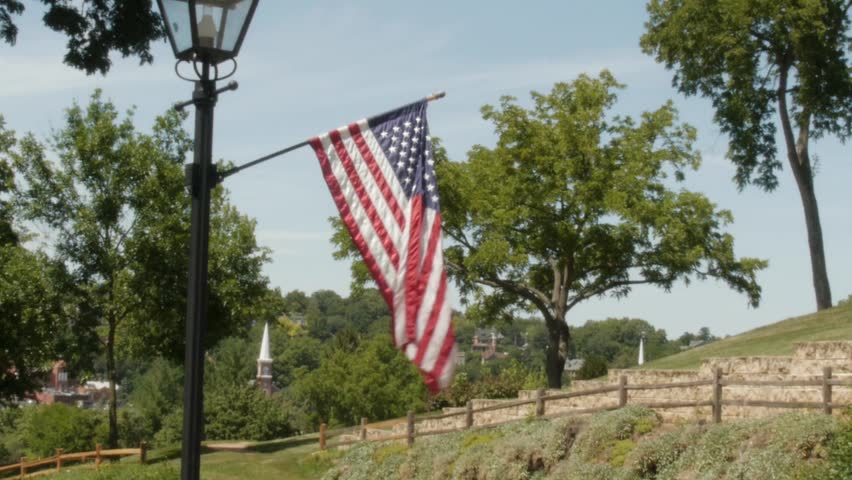 Streetlamp with US flag at Grant House Galena IL. Visitor trolley drives by.