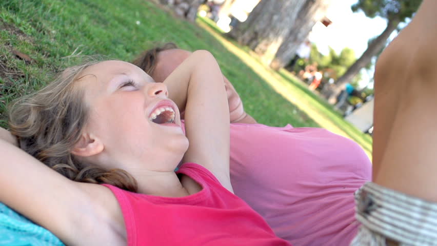 Slow Motion Shot Of A Mother And Daughter Lying On Grass Smiling Happily  