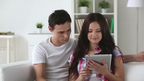 Young couple doing shopping from home via tablet pc