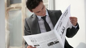 Young entrepreneur beginning his workday with reading the news