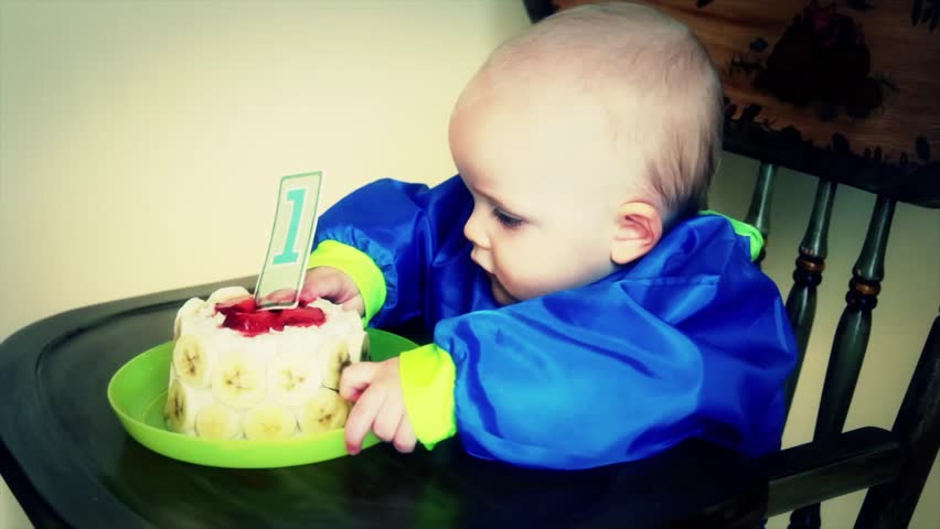 A baby boy eating his first birthday cake