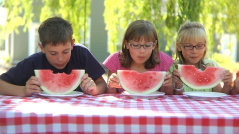 Children eating watermelon outside