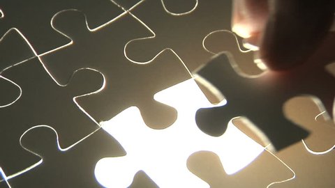 Hand places piece into puzzle Stockvideo