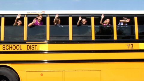 Children waving from school bus
