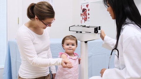 Pediatrician weighing one year old girl