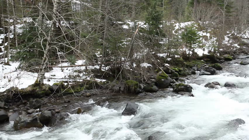 Backpackers standing by river throwing rocks
