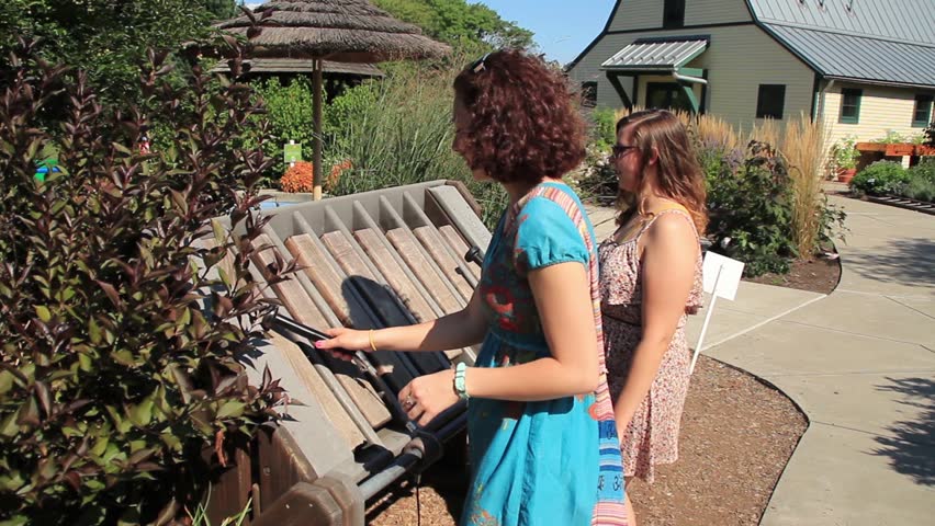 Two young woman play a musical instrument outside at Hershey Gardens.