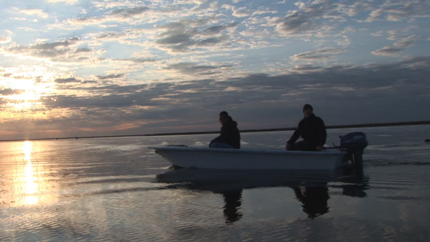 Skiff at Sunset in Louisiana Marsh. Saltwater fishing for Redfish.