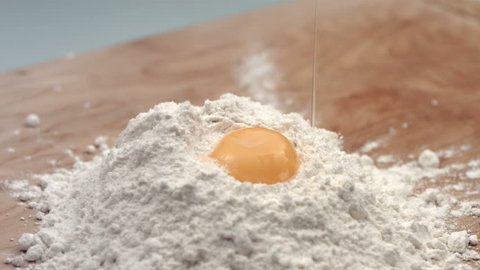 Egg dropping into flour, slow motion Stock Video
