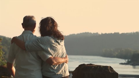 Mature Couple -- embrace overlooking river Video Stok