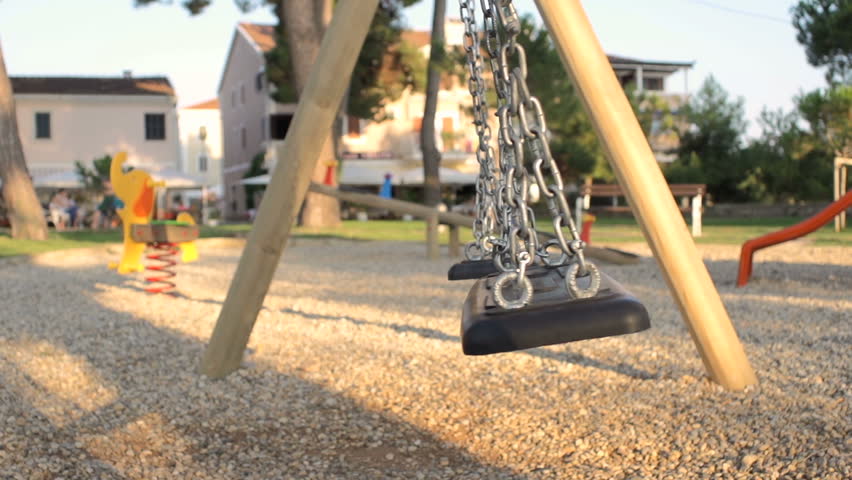 Slow Motion Shot Of An Empty Swing Swinging In The Park