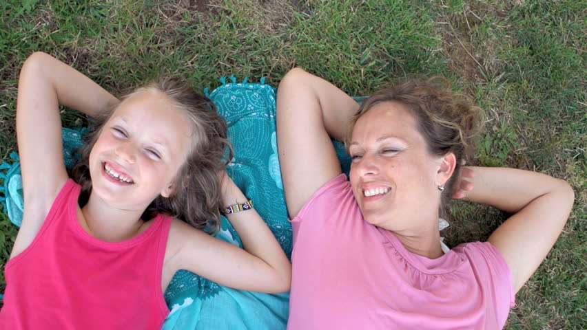 Slow Motion Shot Of Mother And Daughter Lying On The Grass And Laughing