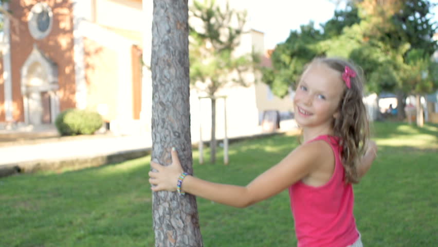 Slow Motion Shot Of A Cute Girl Turning Round A Pine Tree And Smiling Happily In