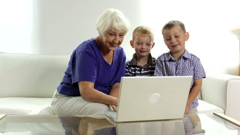Senior woman and two young boys at laptop
