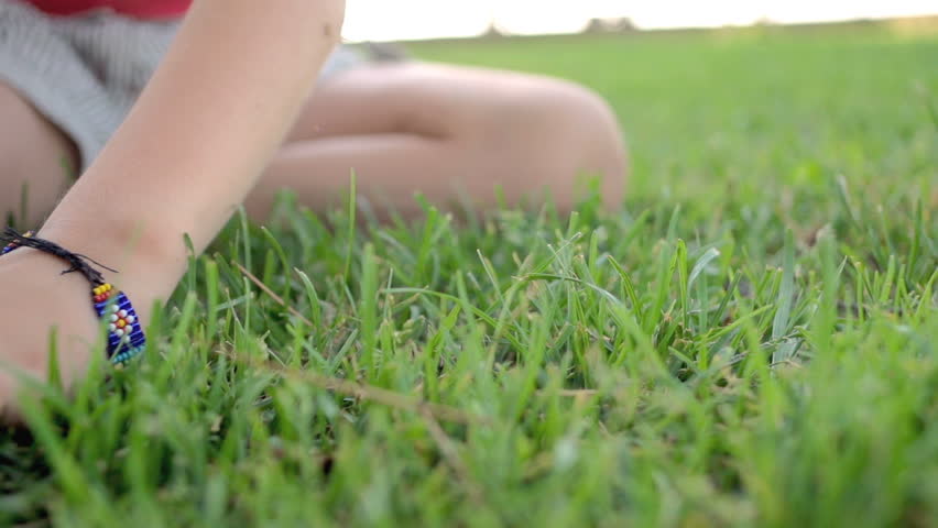 Slow Motion Shot Of A Little Girl's Hand Gently Caressing Green Grass