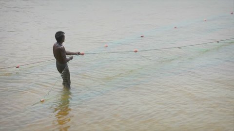 BENTOTA, SRI LANKA - MAY 01: Sri Lankan fisherman pulls net on May 01, 2013 in Bentota, Sri Lanka. Fishing is a key occupation on Sri Lanka sea coast.