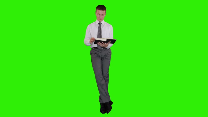 Young businessman reading a book and sitting, Green Screen