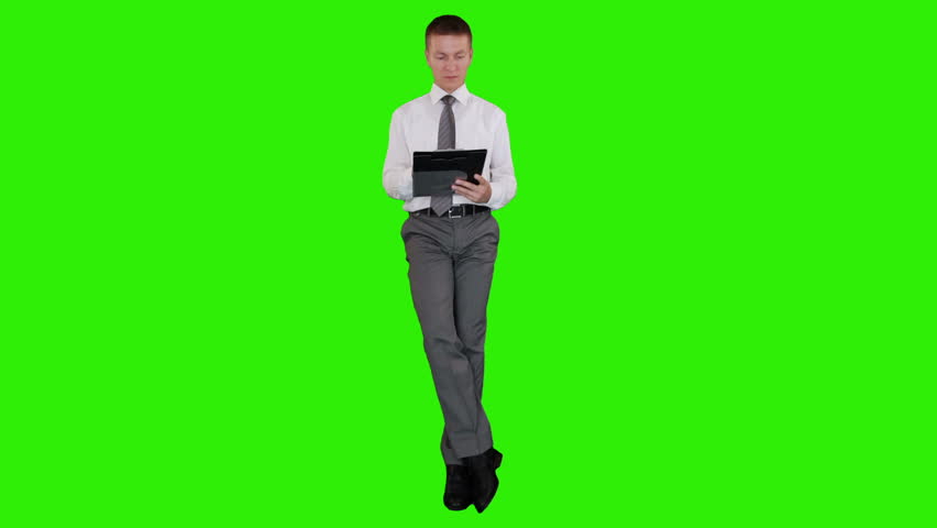 Young businessman writting on a clipboard and sitting, Green Screen